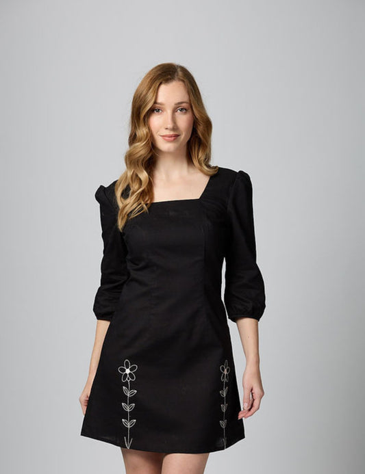 Three-quarter profile of 3/4 sleeve black mini dress with square neck and breathable natural lining.