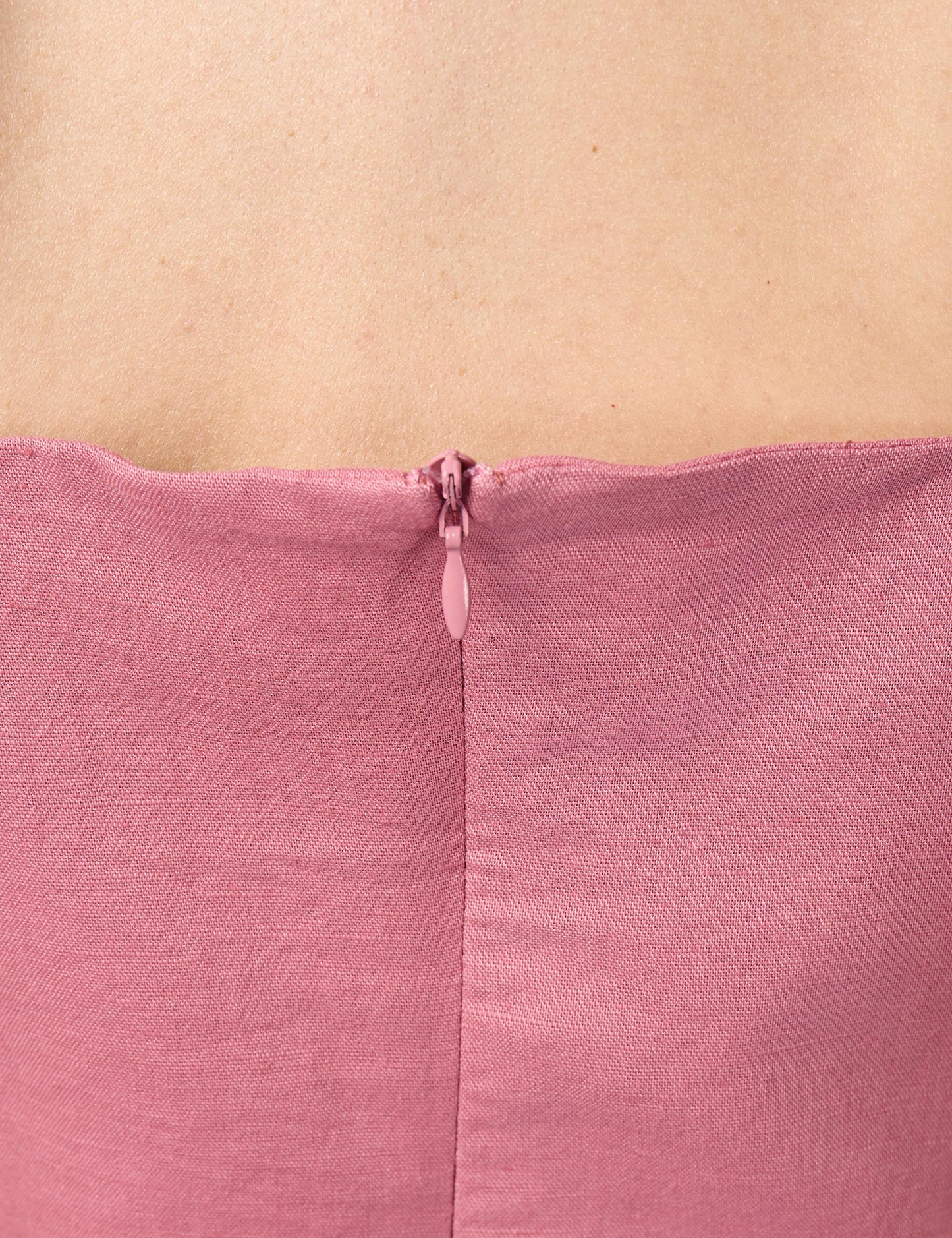 Close-up of high-quality YKK invisible zip enclosure on the back of a pink sustainable luxury dress.
