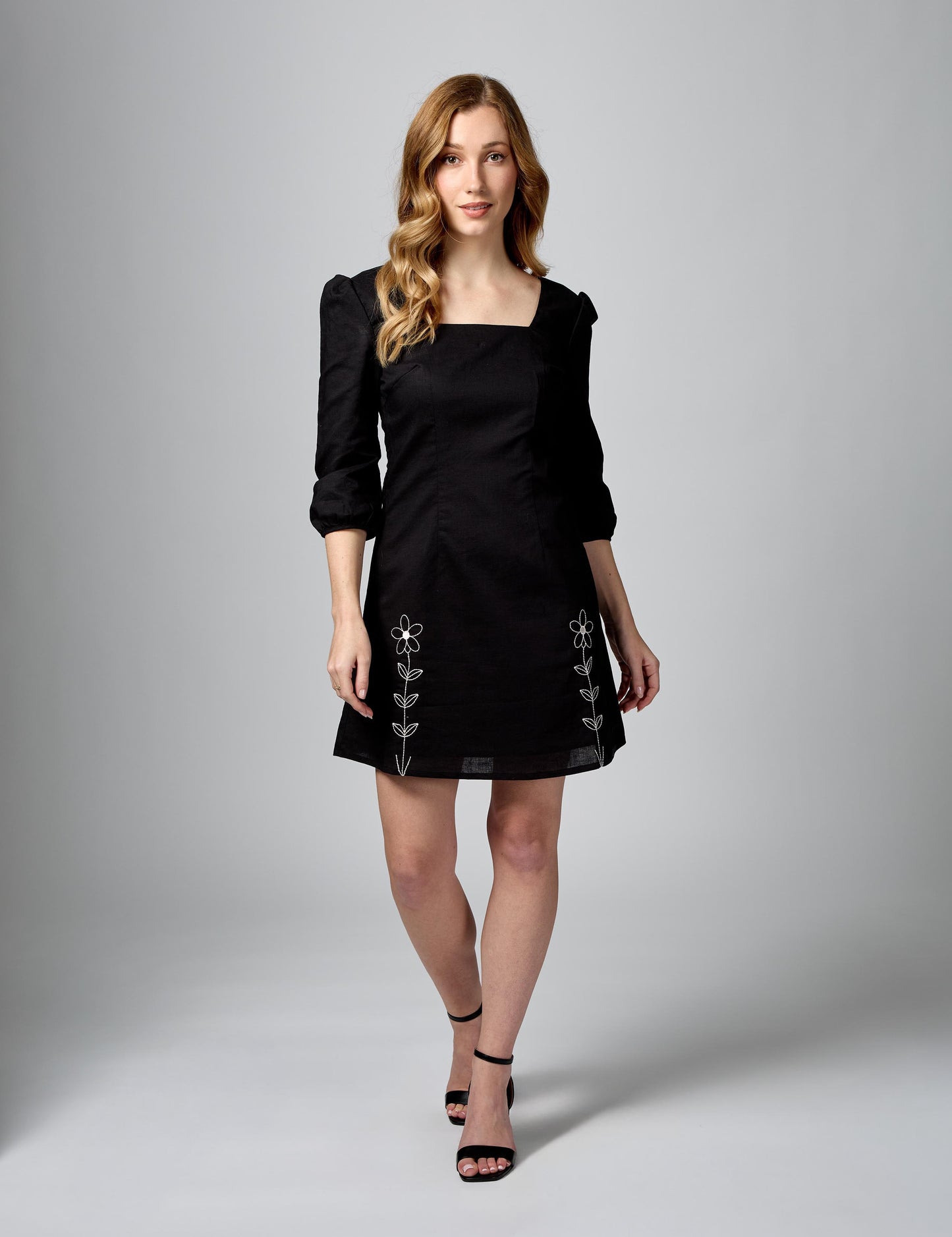 Chic black sustainable dress with 3/4 sleeves in luxury linen-cotton. Front full shot on model.