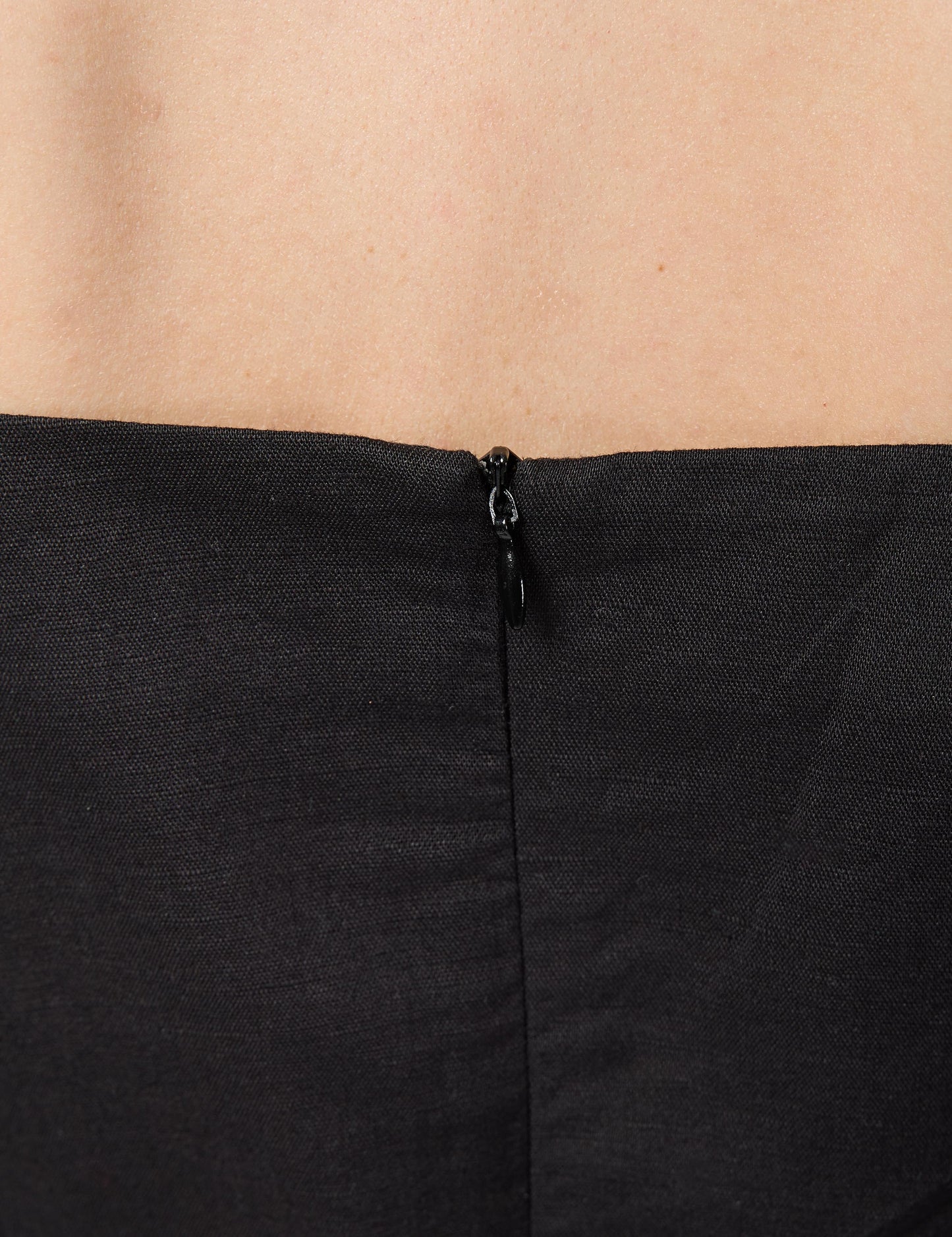 High-quality YKK invisible zip enclosure on the back of a black 3/4 sleeve luxury sustainable dress.
