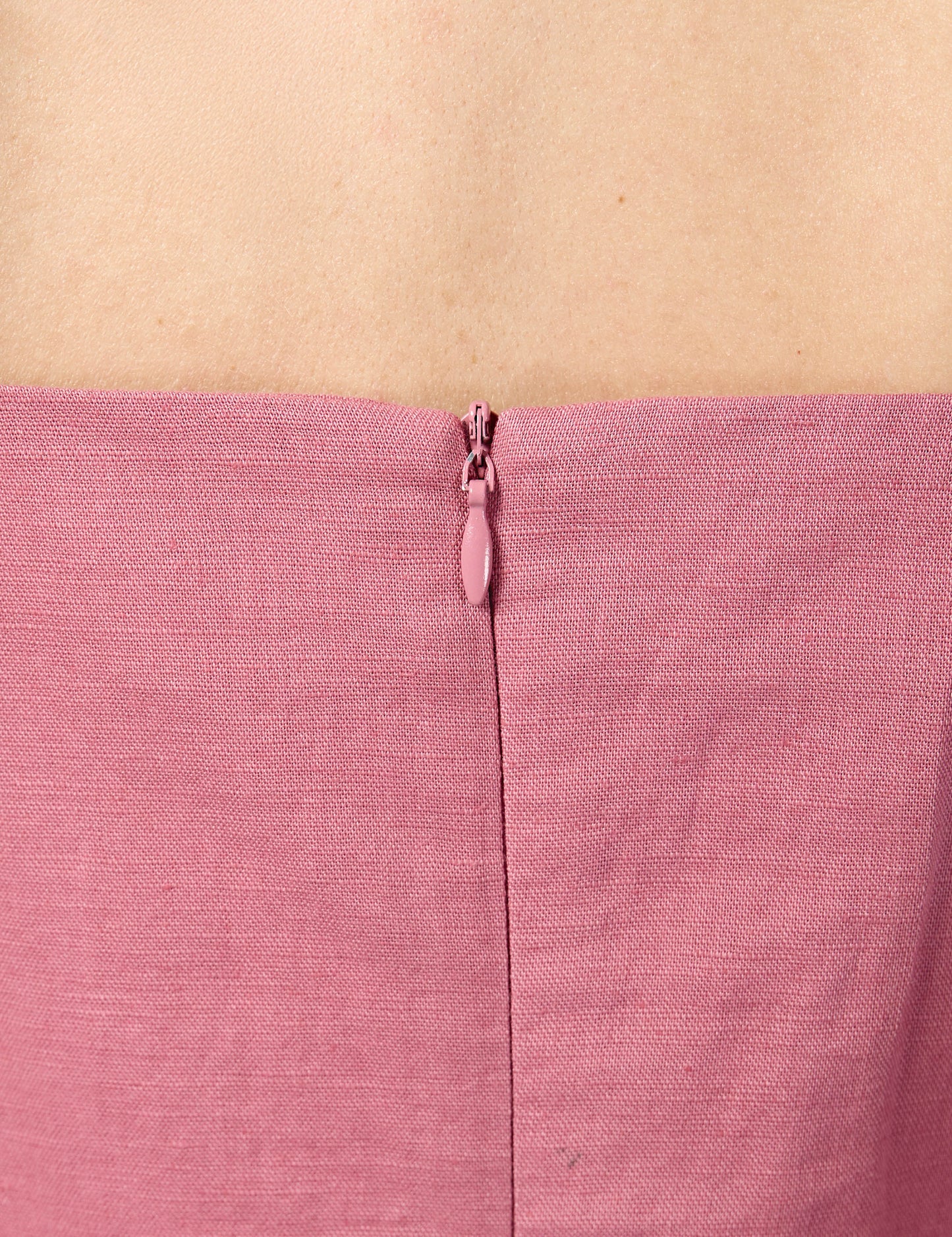 Close-up of high-quality YKK invisible zip enclosure on the back of a pink 3/4 sleeve sustainable dress.