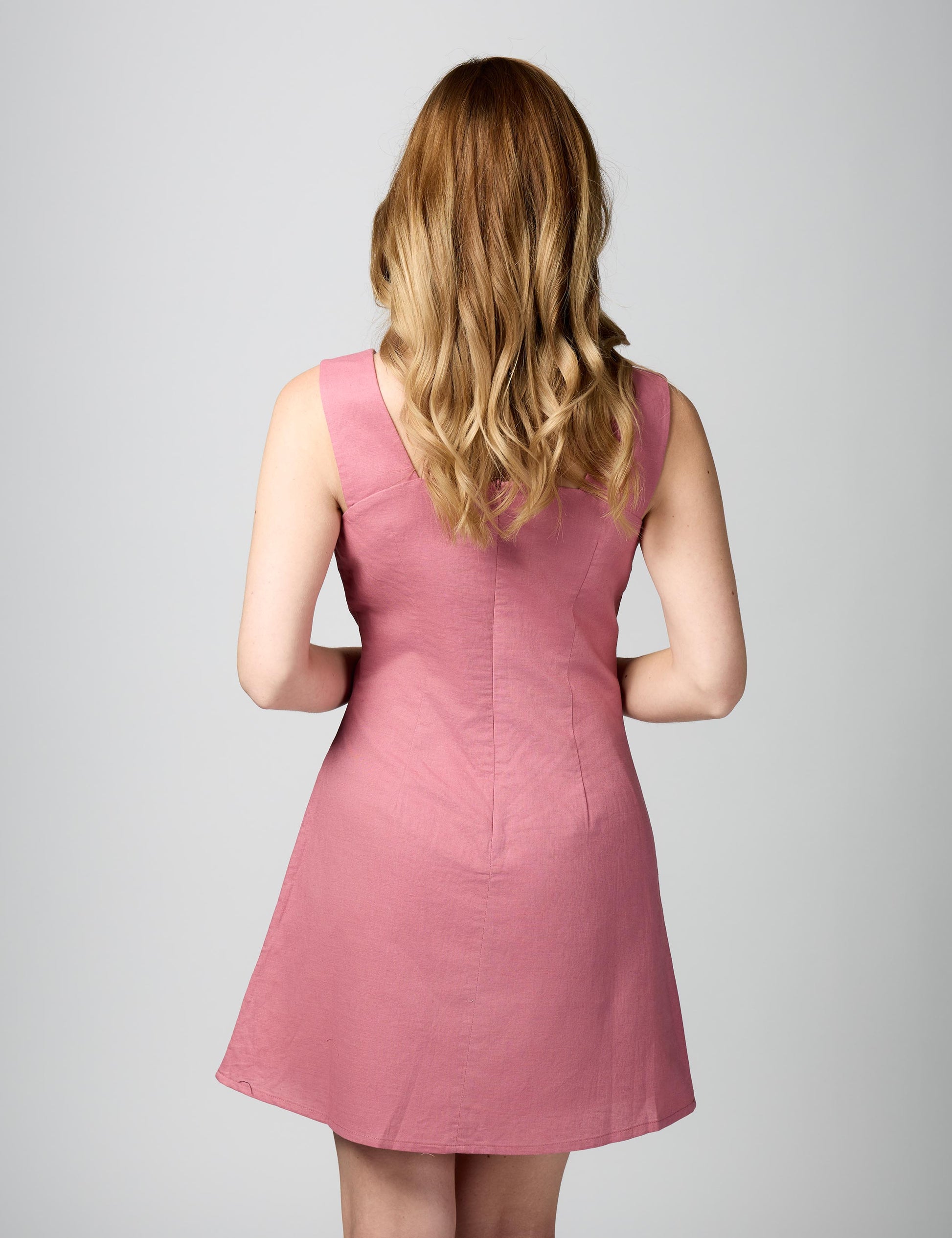 Rear three-quarter profile of pink linen-cotton summer dress highlighting the tailored fit and premium finish.